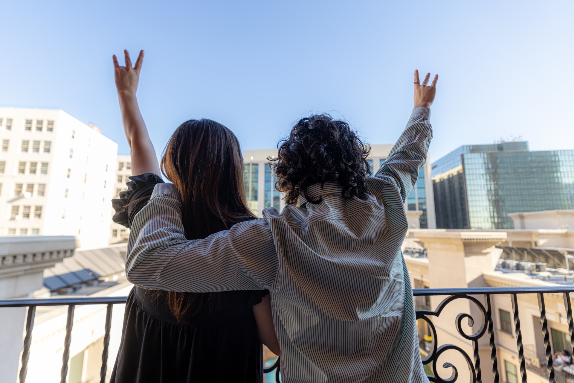 Two students standing on a balcony looking out at the city.
